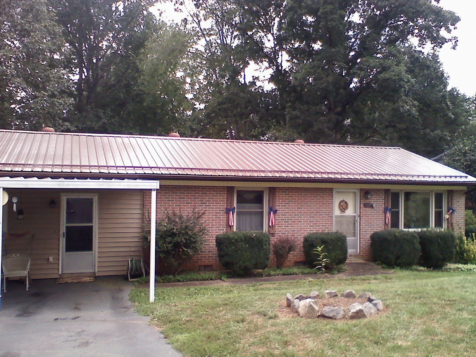 Bronze metal roof and carport on a brick ranch home — Roof Repair work by our crew in Central Falls